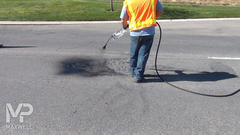 A road crew prepares a raveled and depressed area with primer prior to application of GAP Mastic.