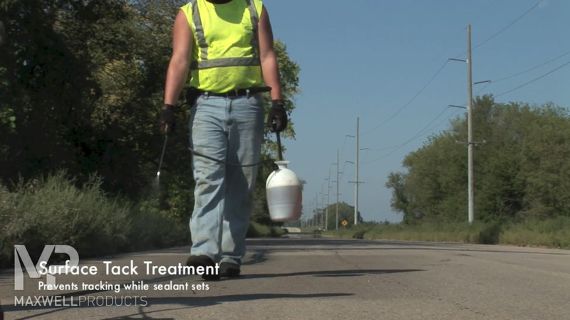 Road crew applies a surface tack treatment to prevent tracking while sealant cures.