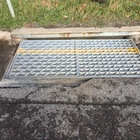 The pavement around a drain is deteriorating, cracking, and distressed.